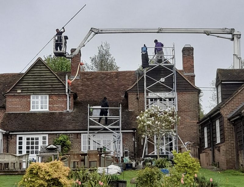 The Moss Cleaners using cherry picker and scaffolding to clean roof safely and professionally in Tetbury, Gloucestershire
